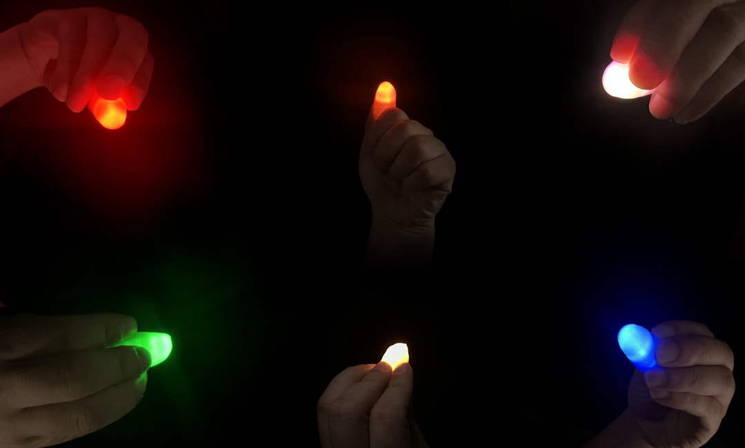 Red, green, blue and white lights on a performer's fingers